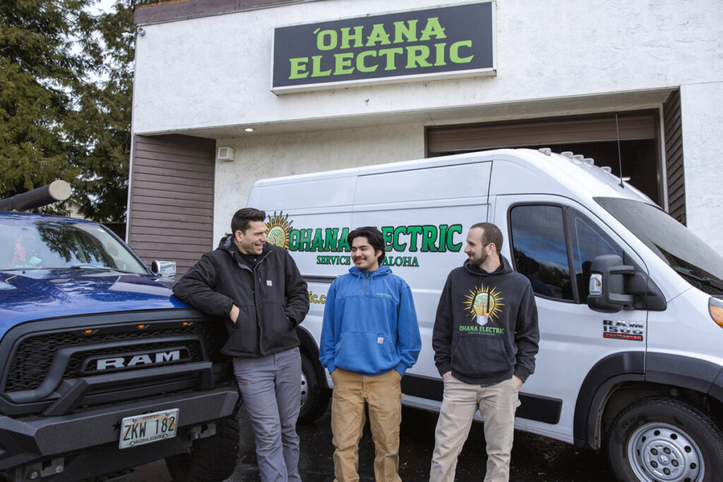 The Ohana electric team. Professional puget sound electricians in front of their electrical equipment.